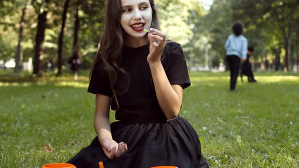 Cute Girl Wearing Demon Costume Eating Candies alt