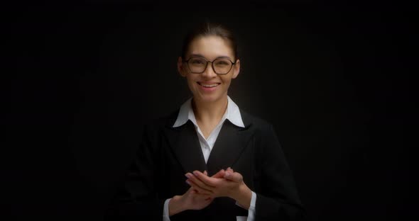 Businesswoman Claps Her Hands Applauds Standing on a Black Background