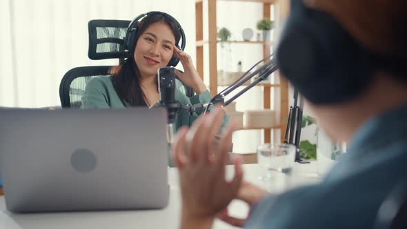 Asia girl radio host record podcast use microphone wear headphone interview celebrity guest content.