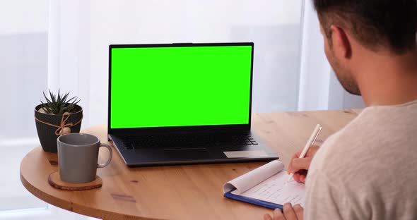 Man Taking Notes With Personal Computer With Mock Up Chroma Key Display