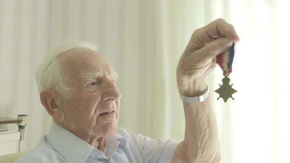 Senior man looking at an old medal