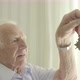 Senior man looking at an old medal - VideoHive Item for Sale