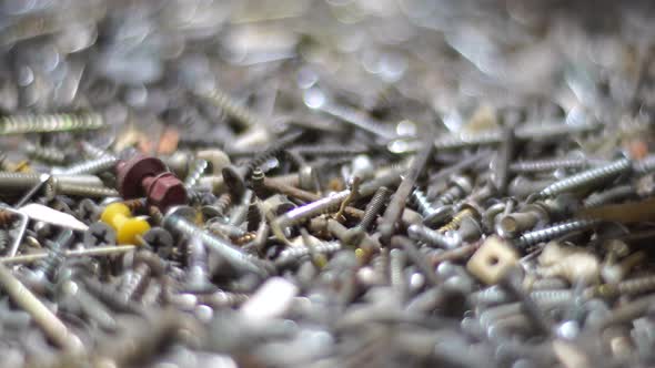 Hand Putting and Sorting Screws Nails Bolts and Washers on the Table alt