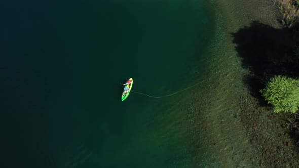 Aerial top down of two experienced dry fly fishers in a kayak close to shore in Lake Steffen, Patago alt