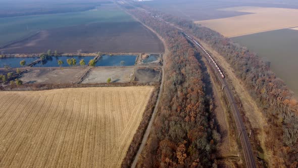 Panoramic Moving Freight Train Along Railway Tracks Trees Agricultural Fields alt