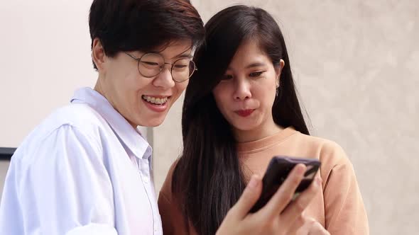 Asian LGBT couples work together at home. Small business entrepreneurs. alt