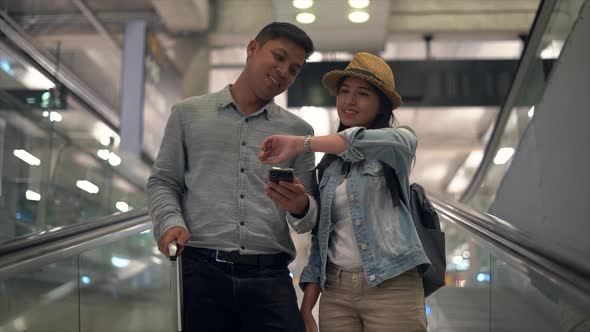 Couple Asian people walking in airport terminal waiting for  flight boarding.