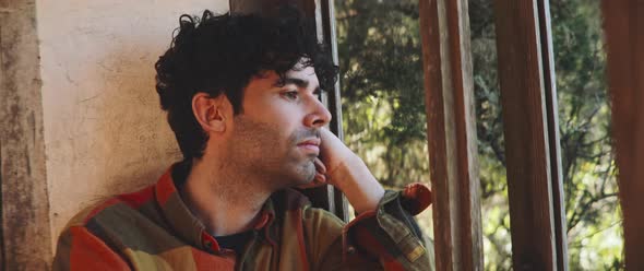 Man looking through window frame on a windy day alt