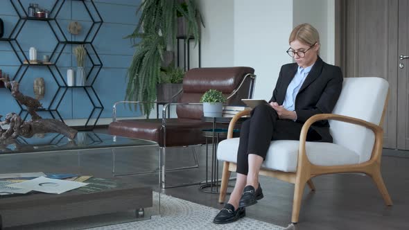 Serious Millennial Businesswoman Professional Using Digital Tablet Sitting In Office alt