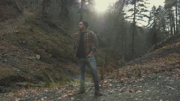 Young Man Standing in Forest. Traveling Concept People in Nature.