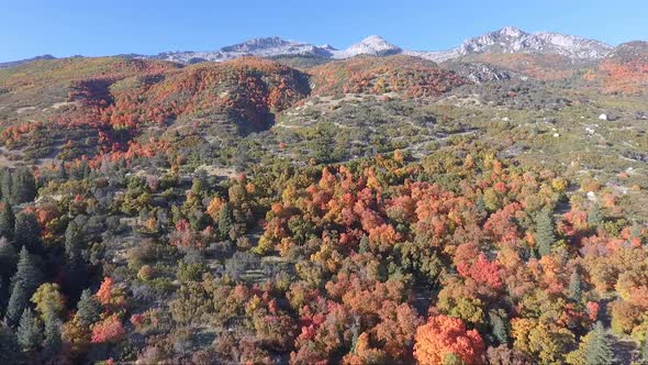 A drone flies over the rocks and slopes of  Dry Creek Trailhead in Alpine, Utah as leaves change int alt