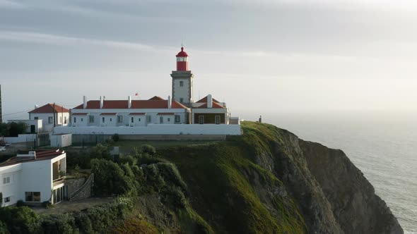 Aerial View of a Lighthouse Surrounded with Rugged Coastline alt