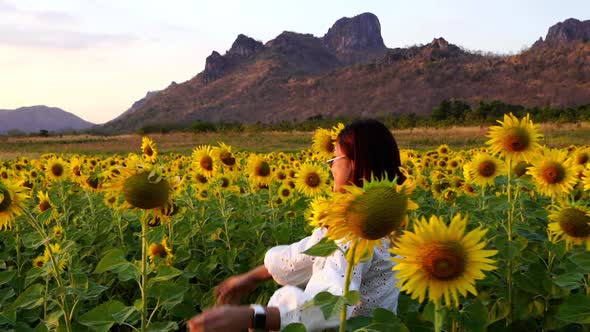 slow-motion of cheerful woman walking and enjoying with sunflower field alt