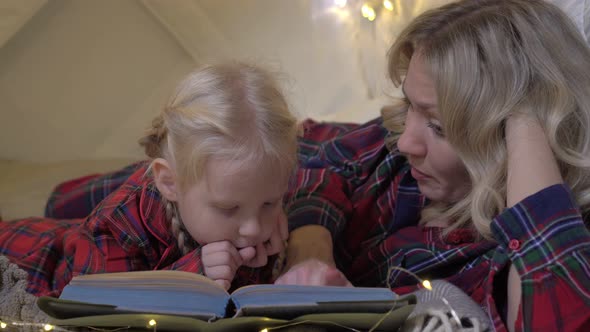 Parents with a Child Read a Fairy Tale Before Bedtime alt