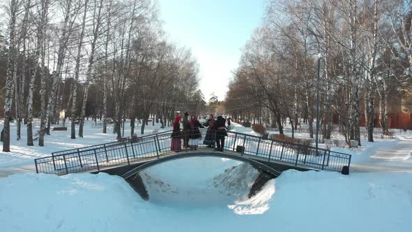 Russian Folklore - People in Russian Costumes Are Dancing on the Bridge in Winter alt