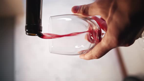 Closeup of Pouring Red Wine From a Bottle Into Glass