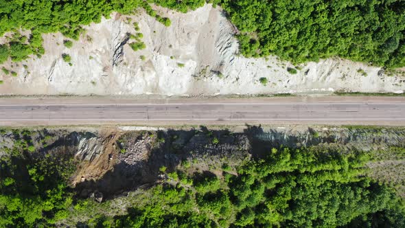 Aerial View Vertically Downward on Blue and White Cars Driving on a Country Road alt
