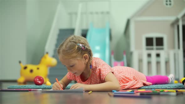 Preschooler Girl Drawing with Crayons on a Floor alt