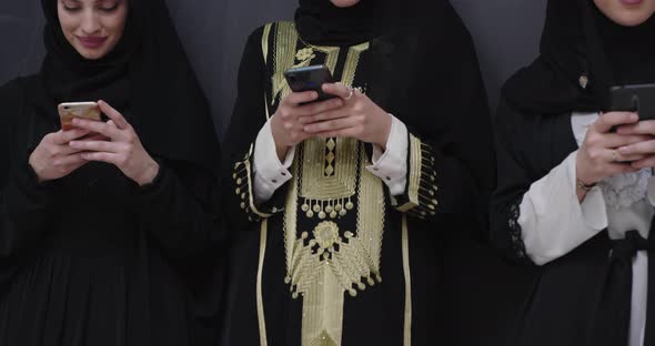Group of Young Beautiful Muslim Women in Fashionable Dress with Hijab Using Mobile Phone alt