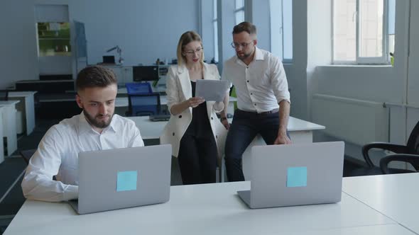 Young Man Work on the Computer and on the Background Sit Coworker alt