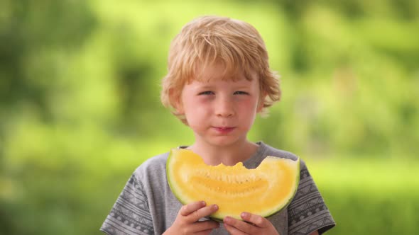 Young Blond Boy Eating Yellow Watermelon