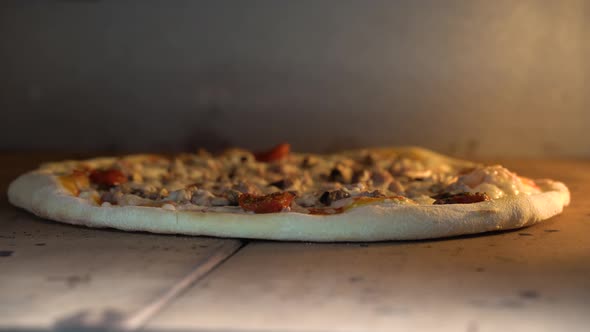 Handheld Close Up of Pizza with Tomato Sauce and Cheese and Chef Checking Pizza for Readiness in the