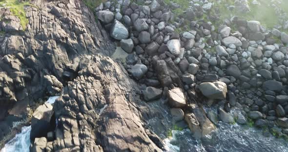 Aerial footage of the the beautifu rocks and sunny beach of Armação in Florianópolis, Brazil. alt