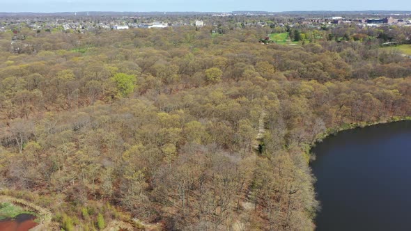 An aerial view of two lakes during the day. The drone pan left and trucks right over the water & dry alt