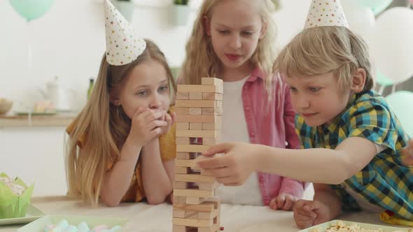 Boy Playing with Wooden Blocks Tower alt
