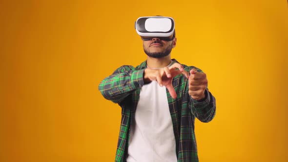 Casual African American Man Using VR Technology Wearing Headset Against Yellow Background alt