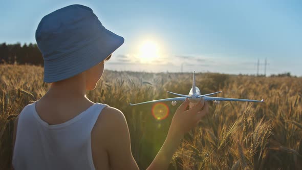 Funny Boy in a Blue Hat Playing with Airplane in the Golden Wheat Field at Sunset Boy Dreams of