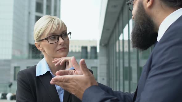 Woman in Suit Listening to Inspired Male Colleague, Discussing Perspectives