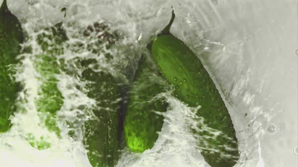 Super Slow Motion Cucumbers Fall Into the Water with Splashes alt