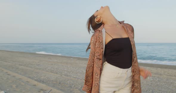 Young girl with black boots has fun on the beach near the sea in Italy alt
