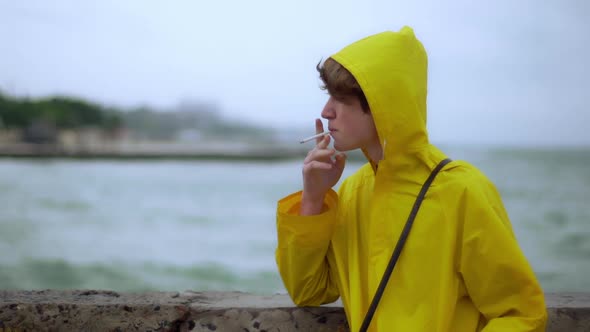 Teenager Smoking on Shore Looks Back Wind Slomo alt