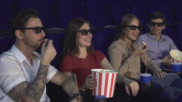 Two Couples Sit in the Cinema and Eat Popcorn alt