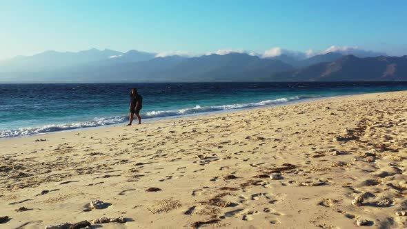 Tourist loves life on tranquil coastline beach break by blue water with white sand background of the alt