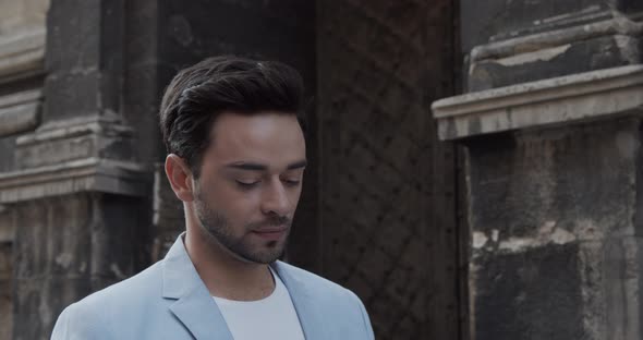 Young Man Rides Near The Ancient Castle In A Festive Light Suit alt