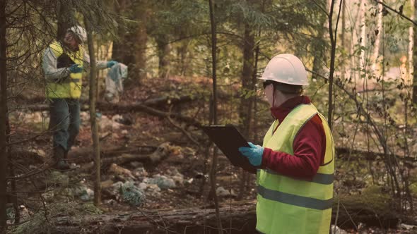 Ecologist Man in Workwear and Helmet Clean Plastic Garbage in Forest