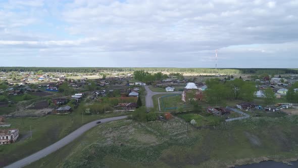 Aerial view of old village with church and old houses on the high bank of the river 12 alt