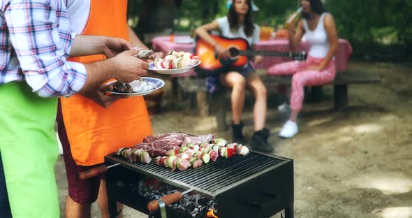 Happy Friends Having a Barbecue Party in Nature alt