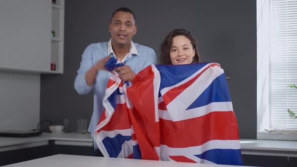 TV POV of Young Interracial Couple with British Flag Rejoicing Winning of National Team in Sports alt