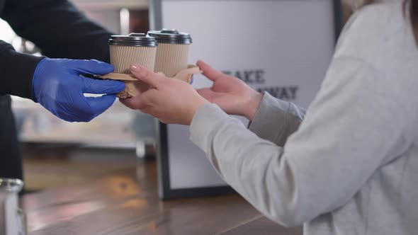 Unrecognizable Male Employee Passing Take Away Coffee to Female Buyer in Cafe alt