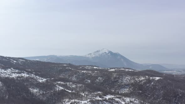 Pyramid shaped top of Rtanj mountain under snow 4K aerial video alt