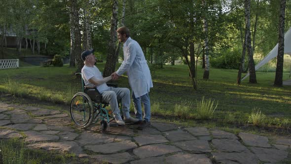 Doctor and Old Man on Wheelchair Meets in the Park alt
