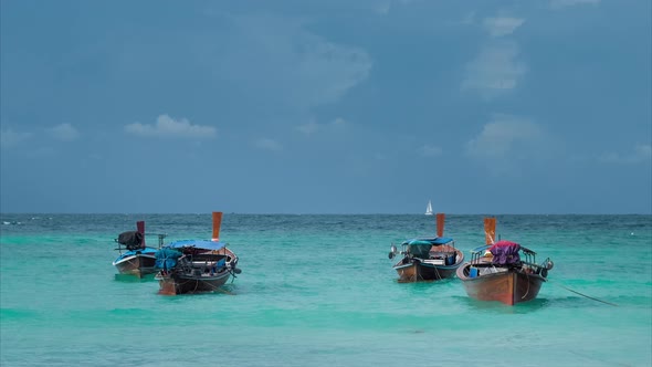 Four Long-tailed Boat Swinging in Blue Waves, White Sail Boat on the Horizon, Koh Lipe Thailand alt
