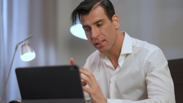 Serious Middle Eastern Manager Explaining Strategy Idea Gesturing Talking Looking at Tablet Webcam alt