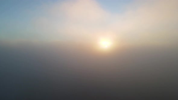 Sunrise Sun Rays in Foggy Hazy Clouds - Aerial Helicopter View alt