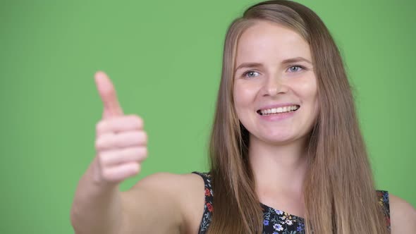 Young Happy Beautiful Woman Thinking and Giving Thumbs Up alt