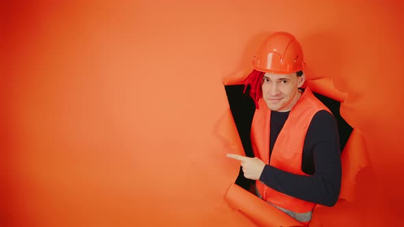 Portrait of Man in Working Uniform with Red Dreadlocks and Pointing Index Finger at Space for Text alt